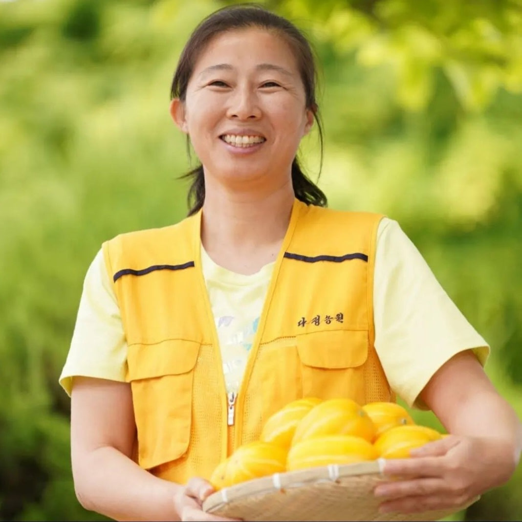 picture of a farmer holding organic golen melons